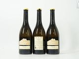 trois bouteilles de vin posées sur une table blanche