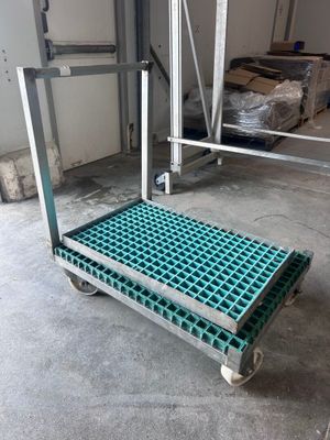 un gros plan sur un chariot à roulettes dans un entrepôt, avec des cartons en arrière-plan