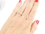 a woman ' s hand with a red manicure holding a diamond ring