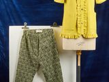 un mannequin portant une chemise jaune et un pantalon vert, sur fond bleu