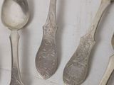five spoons that are sitting on a table