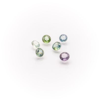 a group of five different colored gems on a white surface