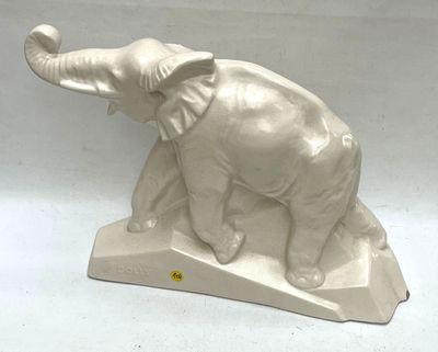 a white elephant statue on a stand on a white surface