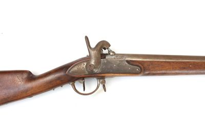 un vieux fusil avec un canon en bois et des accessoires en laiton sur fond blanc