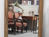 un miroir posé sur le sol à côté d'une chaise