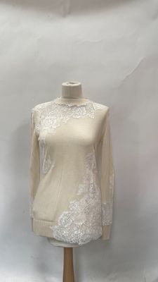 white lace top on a mannequin stand against a white backdrop