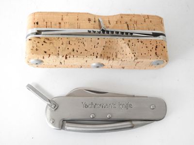 a cork and a knife on a white surface