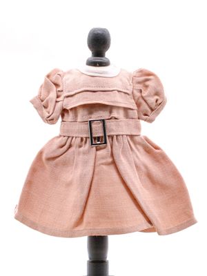 robe rose posée sur un socle de mannequin, avec une ceinture autour