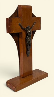 une croix en bois surmontée d'un crucifix, sur fond blanc