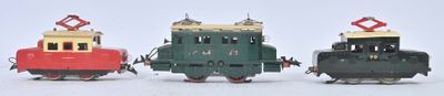 trois petits trains assis côte à côte sur une surface blanche