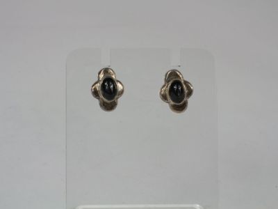 a pair of silver earrings with black stones on them