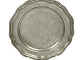 silver plate with scalloped edge on a white background