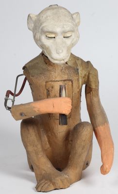 une statue représentant un singe tenant un marteau à la main