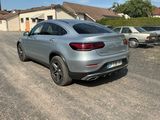 the mercedes gle is parked in a parking lot next to a house