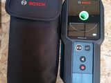 the bosch handheld is sitting next to a pouch on the floor