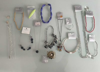 many different necklaces and bracelets displayed on a table