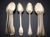 four silver spoons and two silver spoons sitting side by side
