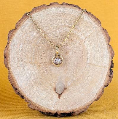 Collier plaqué or jaune orné d'un diamant blanc sur une tranche d'arbre