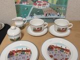 quatre assiettes et tasses posées sur une table, avec en arrière-plan une photo d'une ville