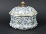 une petite boîte bleue et blanche surmontée d'un oiseau