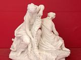two figurines of a woman and a child on a red surface