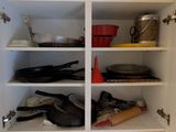 une cuisine équipée d'un évier et d'un placard sur lequel sont posés de la vaisselle