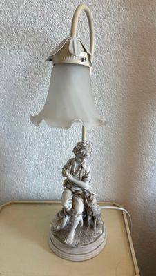 Lampe en résine représentant un jeune berger et son chien.