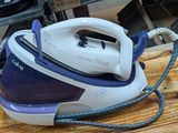 a blue and white steam iron sitting on a wooden table
