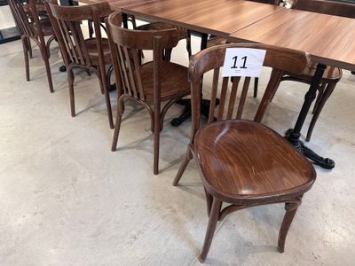Dans un magasin, des tables et des chaises sont alignées, chacune portant une étiquette de prix