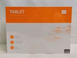 La boîte de la tablette est posée sur la table, prête à être ouverte.