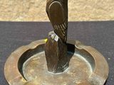 an image of a bronze owl statue on a metal ashtray