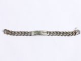 a close up of a metal bracelet on a white surface