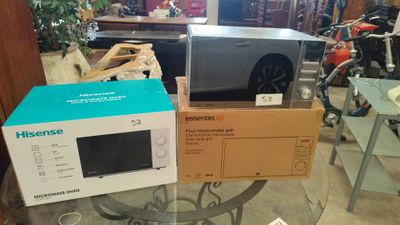 deux micro-ondes posés sur des cartons, sur une table