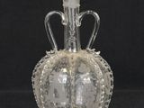a clear glass bottle with a handle on a black background