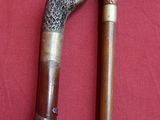 two old canes that are on a red cloth