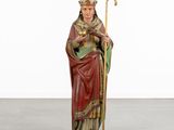 a statue of a man holding a staff and wearing a crown