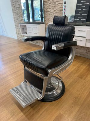 une photo d'un fauteuil de coiffeur dans un salon de coiffure pour hommes