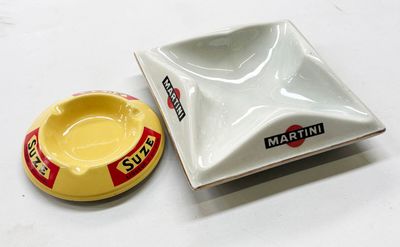 un petit cendrier et un autre petit cendrier posés sur une table blanche