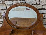 an image of a mirror sitting on top of a wooden dresser
