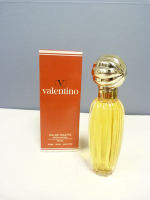 une image représentant un flacon de parfum posé à côté d'un coffret de parfum