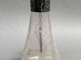 a glass bottle with a silver lid and a spoon in it