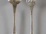 deux cuillères et une fourchette en argent sur une table