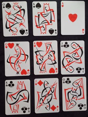 des cartes à jouer ornées de motifs rouges et noirs, posées sur une table