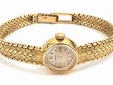 an image of a woman ' s wrist watch on a gold bracelet