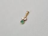 un pendentif en émeraude et diamants sur un fond blanc