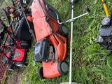 many lawn mowers and lawn mowers laying on the grass