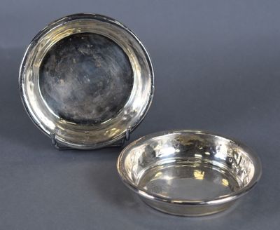 a pair of silver plated dishes on a grey background