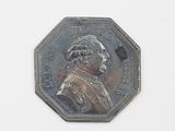 une pièce d'argent sur laquelle figure l'image d'un homme