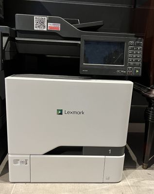 the printer is sitting on top of the desk next to the printer
