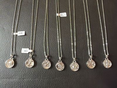 a collection of silver necklaces on a black surface